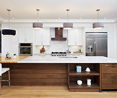 Stunning kitchen with off white perimeter, clear alder island and accent wood range hood